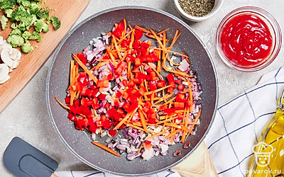 Начните приготовление. Сковороду поместите на небольшой огонь, влейте в нее оливковое масло и оставьте разогреваться. Пока масло греется, измельчите чеснок и лук. После этого выложите ингредиенты на сковороду и обжарьте в течение нескольких минут, постоянно помешивая. Затем добавьте морковь и оставьте смесь еще на 5 минут. В конце выложите в сковороду сладкий перец, перемешайте с остальными ингредиентами и обжарьте еще в течение 2 минут.