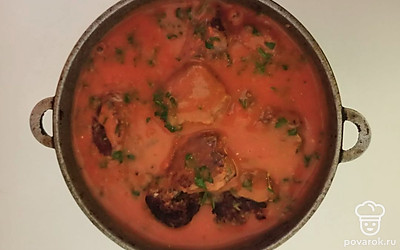 Томатно-сметанный соус с зеленью влейте в казан с тефтелями. Казан поставьте на маленький огонь, доведите до кипения и тушите 10-15 минут под закрытой крышкой. За это время иногда помешивайте тефтели в соусе, чтобы они не пригорели.