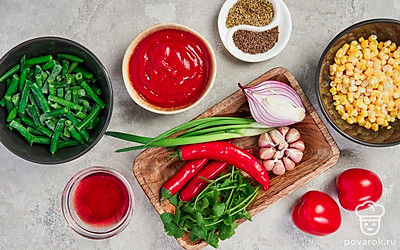 Стручковую фасоль промойте, кукурузу разморозьте. Помидоры помойте, удалите плодоножки, обдайте кипятком и очистите от шкурки. Красный лук и чеснок почистите и помойте. Перец чили помойте, удалите плодоножку и семена. Кинзу и зеленый лук помойте и обсушите. Подготовьте блендер.