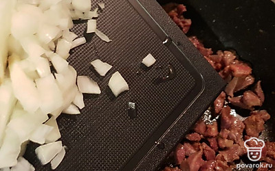 Лук почистите и нарежьте кубиком, добавьте к желудкам. Готовьте 5 минут. 