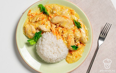 Положите в тарелку порцию риса, рядом выложите курицу в соусе. Украсьте порцию свежей зеленью. 