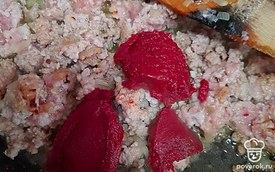 К обжаренному фаршу и луку добавить томатную пасту, перемешать.