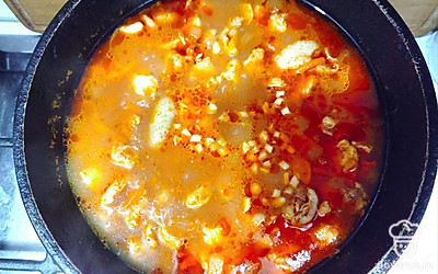 Влить горячую воду, добавить нарезанный чеснок и тушить 20 минут до готовности. 