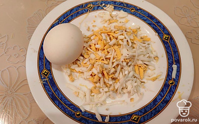 Вареные яйца остудите, очистите от скорлупы и натрите на крупной терке. 