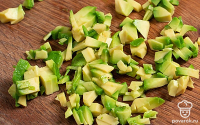 Разрежьте авокадо пополам и удалите косточку. Аккуратно выньте мякоть ложкой и нарежьте одну половину авокадо на мелкие кубики.