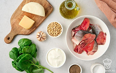 Вымойте и обсушите рыбу. Помойте петрушку и базилик. Снимите шелуху с чеснока. Подготовьте форму для запекания.