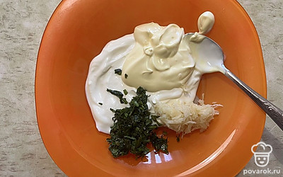 Выложите в емкость тертый чеснок и мелко нарезанную зелень.