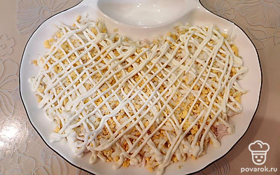 Выложите слой из яиц. Посолите щепоткой соли. Выложите сеточку из майонеза (1 столовая ложка). 