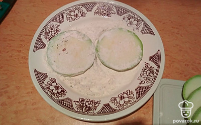 На отдельную плоскую тарелку насыпьте муку. На сковороду налейте растительное масло. Когда оно нагреется, обваляйте кольца кабачка в муке и выложите на сковороду, обжаривайте с двух сторон до появления золотистой корочки.