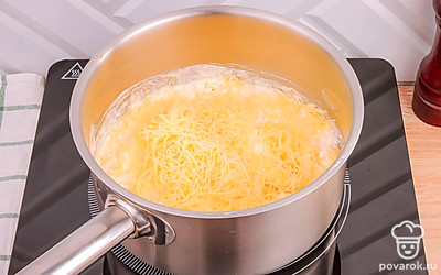 Добавьте в сотейник чеснок и тертый сыр, помешивая, дождитесь, когда сыр расплавится и образуется единая консистенция.