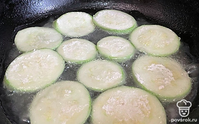 Кружки кабачка обваляйте в муке и обжарьте до румяности с двух сторон. Выложите кружки кабачка на салфетку, чтобы впиталось лишнее масло.