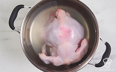 Налейте в кастрюлю воду больше, чем наполовину. Поставьте на сильный огонь и доведите до кипения. Аккуратно положите курицу в кипящую воду.