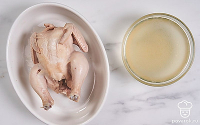 Помогая себе вилками, достаньте курицу из бульона, выложите тушку в глубокую тарелку. Дайте птицу полностью остыть, а бульон процедите.