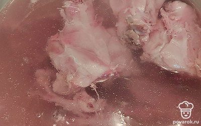 Помойте курицу и положите её в кастрюлю с кипящей водой. Снимите пену.