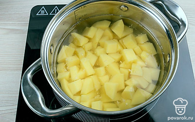 Картофель нарежьте небольшими кубиками, переложите в кастрюлю и добавьте воды, подсолите, поставьте вариться. Варите до готовности.