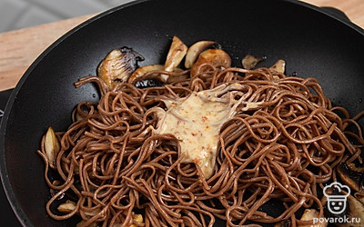 На огонь поставьте сковороду, как разогреется, добавьте масло и грибы. Как грибы приобретут золотистый цвет, добавьте гречневую лапшу. Перемешайте. Добавьте ореховый соус и еще раз перемешайте.