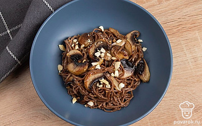 Орехи мелко порежьте. Лапшу переложите на тарелку и посыпьте порезанными орехами.