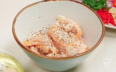 Подготовьте креветки. Посыпьте их солью и перцем.