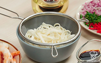 Сварите лапшу. Вскипятите воду, подсолите, спустите лапшу, варите, как написано на упаковке (в среднем 7-8 минут). Слейте воду, прополощите готовый продукт под струей холодной воды.