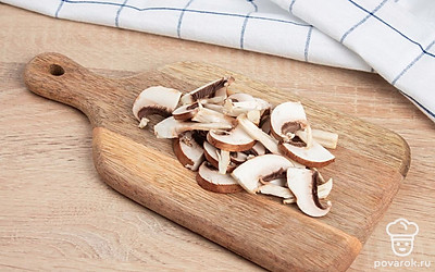 Тонкими ломтиками нарежьте шампиньоны. Лук нарежьте мелкими кубиками.