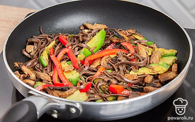 Добавьте лапшу на сковородку, залейте блюдо соевым соусом и готовьте в нем на среднем огне в течении еще 10-15 минут.