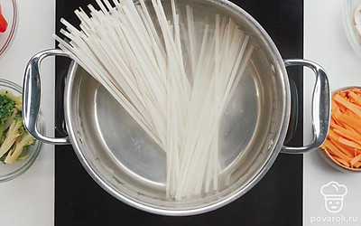 Отварите лапшу удон до полуготовности в подсоленной воде.