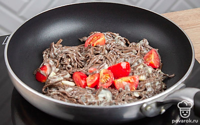 Вылейте на сковороду оливковое масло. Выложите на нее чеснок, помидоры, сыр и прованские травы и лапшу. Обжарьте ингредиенты в течении 10-15 минут на среднем огне, хорошо помешивая.