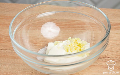 В подходящей по размеру емкости подготовьте соус: смешайте сметану, мелко нарубленный чеснок и соль.