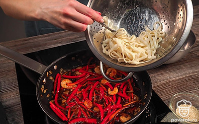 Обжарьте овощи. В сковороде с растительным маслом обжарьте лук 2-3 минуты. Добавьте морковь и болгарский перец. Перемешайте. Обжаривайте еще 3 минуты. Выложите к овощам креветки. Обжаривайте 3 минуты, помешивая. Влейте соус терияки. Добавьте молотый черный и красный перец. Уменьшите огонь, накройте крышкой и тушите 3 минуты. Выложите в сковороду удон. Перемешайте. Обжаривайте еще 3-4 минуты.