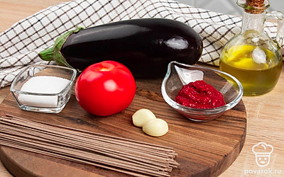 Сварите собу в кипящей подсоленой воде. Время варки уточните на упаковке с лапшой. В среднем лапша из гречневой муки варится 5-8 минут. Помойте баклажан и помидор. Нарежьте помидор на кусочки среднего размера. Чеснок очистите и порубите.