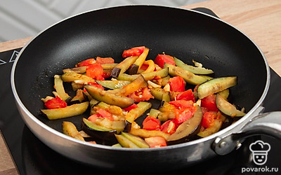 Раскалите сковороду. налейте в нее немного оливкового масла. Обжарьте баклажан, помидор и чеснок. Обжаривайте на высоком огне 5-8 минут. Не забывайте активно перемешивать.