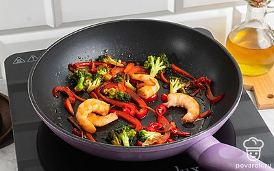 Поставьте воду, дождитесь кипения. Закиньте в кастрюлю собу. Отварите лапшу в подсоленной воде в течении 15-20 минут. Налейте оливковое масло на сковороду. Выложите на сковороду жгучий перец чили, чеснок, морковь, болгарский перец, брокколи и креветки. Посолите их.Обжарьте ингредиенты в течении 15-20 минут на среднем огне до золотистой корочки.