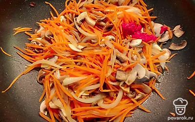 Мясо, после обжарки, переложите в тарелку, а в сковороду добавьте оставшуюся порцию подсолнечного масла. Порежьте грибы небольшими кусочками произвольной формы. Обжарьте на сковороде лук и морковь с шампиньонами. Когда лук станет прозрачным, добавьте томатную пасту и обжарьте на сильном огне несколько минут.