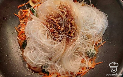 Когда шпинат и грибы сильно уменьшатся в размере, выпустив сок, а овощи станут мягкими, добавьте к ним фунчозу, а сверху полейте все приготовленным соусом. Тушите под крышкой еще 3 минуты.