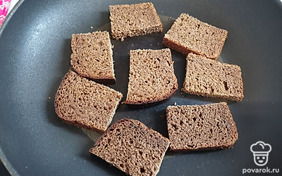 Ломтики хлеба разрежьте на порционные квадраты и подрумяньте на сухой сковороде. 