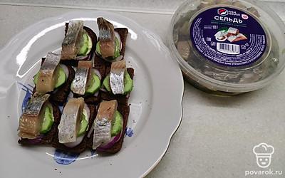 Затем выложите кусочки малосольной сельди. 