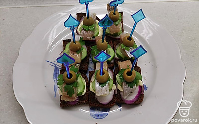 Украсьте листочком петрушки и половинкой оливки. Наколите канапе на шпажку. 