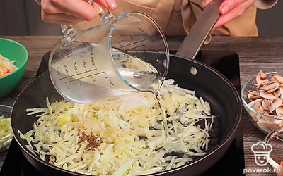 Приготовьте капусту. Разогрейте на сковороде масло. Выложите в сковороду свежую капусту. Посыпьте солью, тмином и сахаром, перемешайте. Залейте 1 стаканом воды. Убавьте пламя до минимума. Тушите капусту около 15 минут до размягчения.