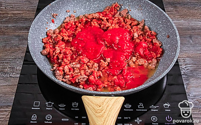 Когда фарш обжарится до полуготовности, добавьте томатный соус. Влейте полстакана чистой воды. Перемешайте. Когда жидкость закипит, убавьте огонь и накройте крышкой. Оставьте тушиться соус болоньезе минут на 20-30.