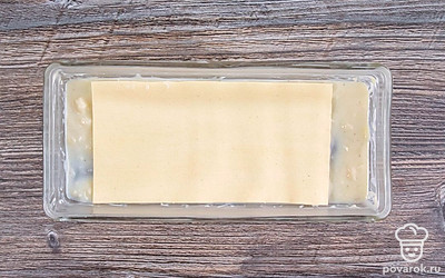 В зависимости от размера формы и количества порций, сверху на бешамель выложите в один слой листы пасты.