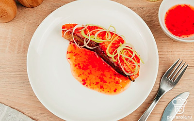 Перед подачей украсьте стейк из лосося тонко нарезанными кружочками репчатого лука.