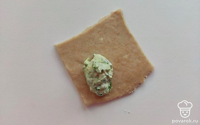 Подготовленное тесто раскатайте в пласт толщиной 1 сантиметр, нарежьте квадратиками 5х5 сантиметров, на готовые квадраты выложите по чайной ложке начинки, сложите в треугольник, после чего согните верхний уголочек и соедините между собой два оставшихся угла. Варите в подсоленной воде 5-7 минут.
