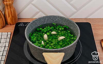 Залейте горошек водой, добавьте зубчики чеснока и отварите.