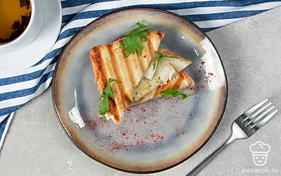 Тост с замороженными морскими гребешками положите на тарелку для подачи и рядом разложите листья руколы.