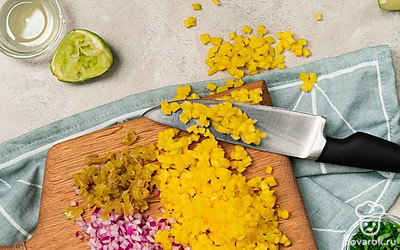 Измельчите продукты для сальсы. У манго удалите косточку, снимите кожицу. Порежьте красный лук, чили и манго маленькими кусочками. Мяту и петрушку измельчите. Из половины лайма выжмите сок.