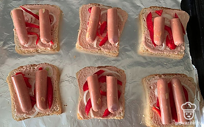 Сосиски разрежьте и выложите на хлеб.