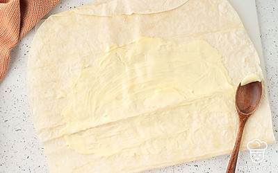 Промажьте половину лаваша тонким слоем майонеза.