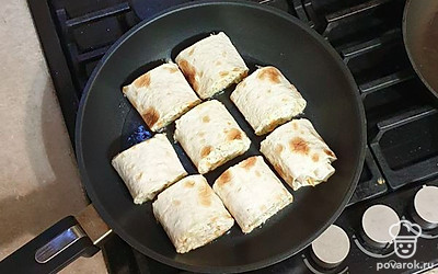 Лаваш аккуратно сверните в рулет. Рулет нарежьте на равные кусочки и выложите на разогретую сковороду. Жарьте на небольшом огне до золотистой корочки с каждой стороны.