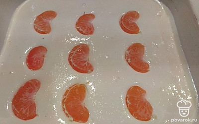 Переложите массу в форму для запекания. Сверху выложите дольки очищенных мандаринов и отправьте в разогретую до 170 градусов духовку на 20 минут.