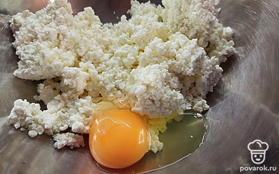 Творог выложите в миску и вбейте яйцо. 